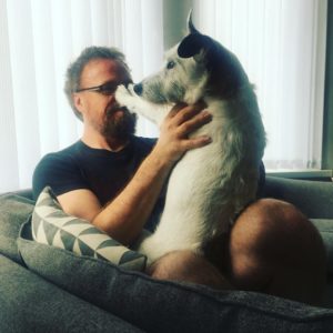 Photo of Kai Jones, at home with his dog, Patches.