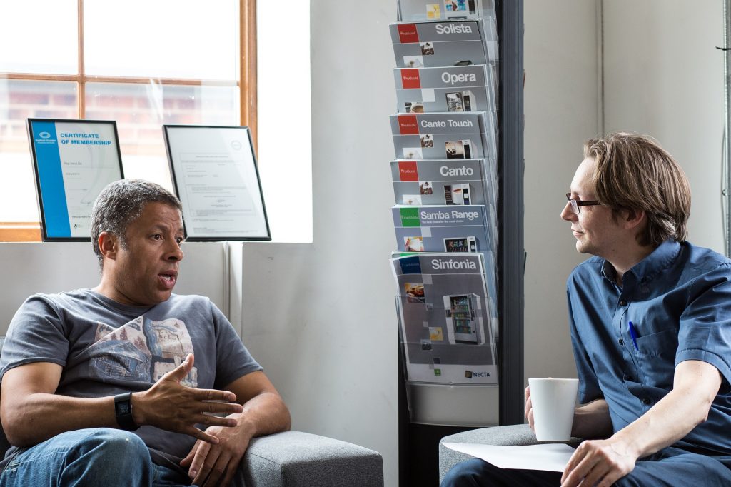 Two men sitting in easy chairs having a relaxed conversation