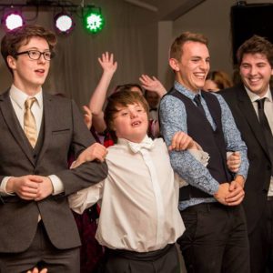 Young man in smart clothes celebrating his birthday with friends