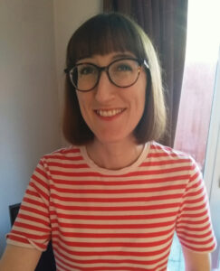 Young woman with glasses and bobbed hair wearing a stripy red and white tshirt