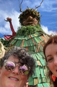 A selfie of 2 women in front of the Green Man at Green Man festival. 