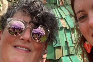 A selfie of 2 women in front of the Green Man at Green Man festival.