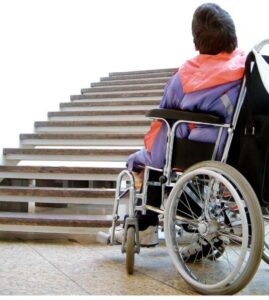 woman in a wheelchair looking up a flight of stairs