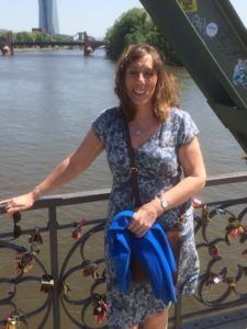 Photo of Karen Warner standing on a bridge, next to Cardiff Bay, smiling