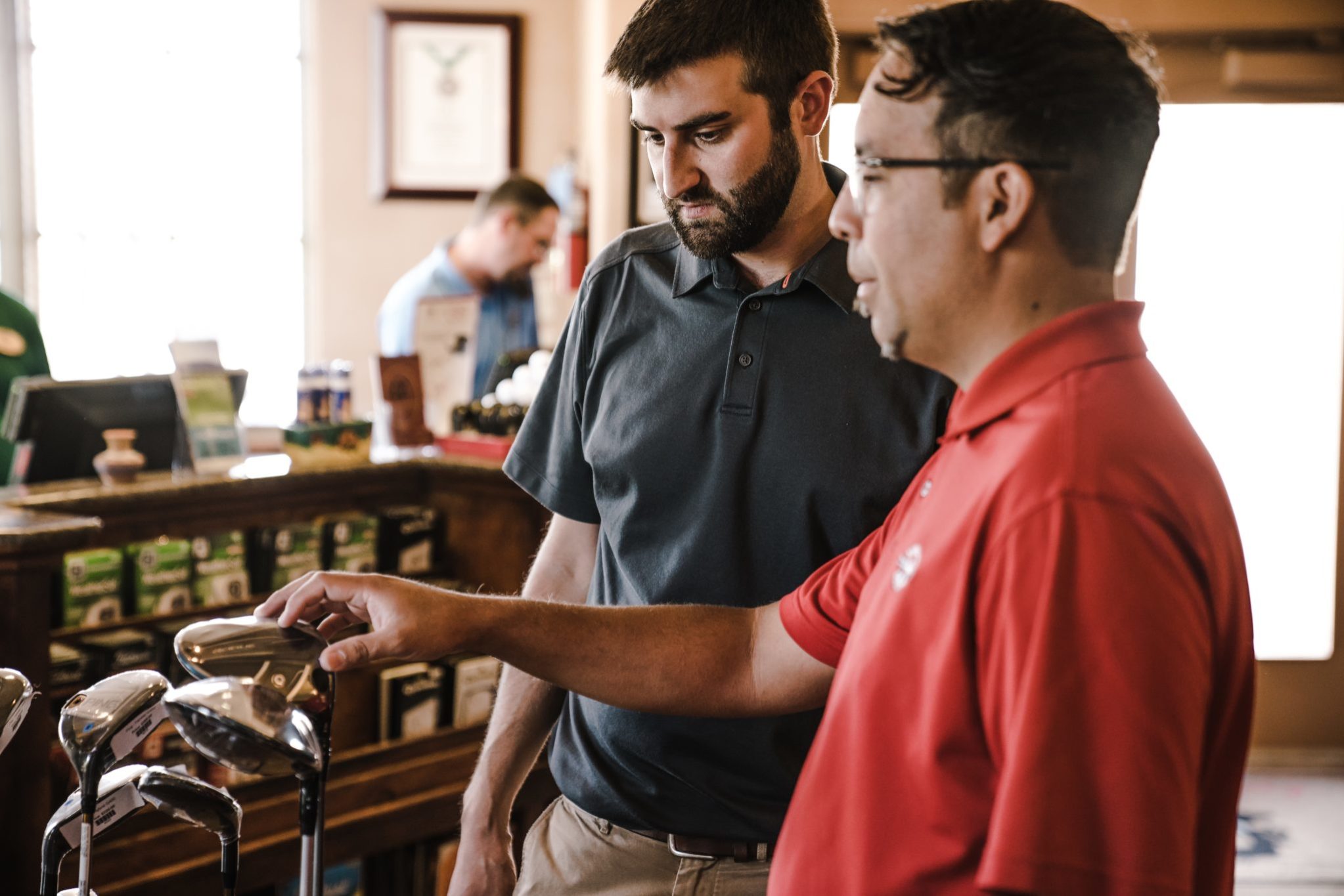 Two men choosing golf clubs