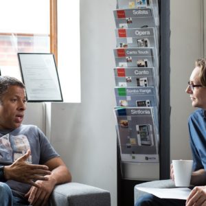 Two men sitting in low chairs in an office talking