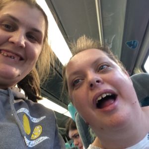 Selfie taken by two young women on a train, they are smiling and look excited
