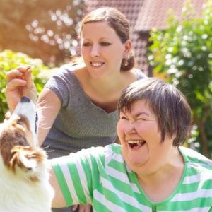 Two women petting a dog.