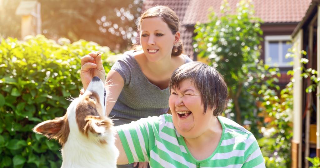 Two women petting a dog.