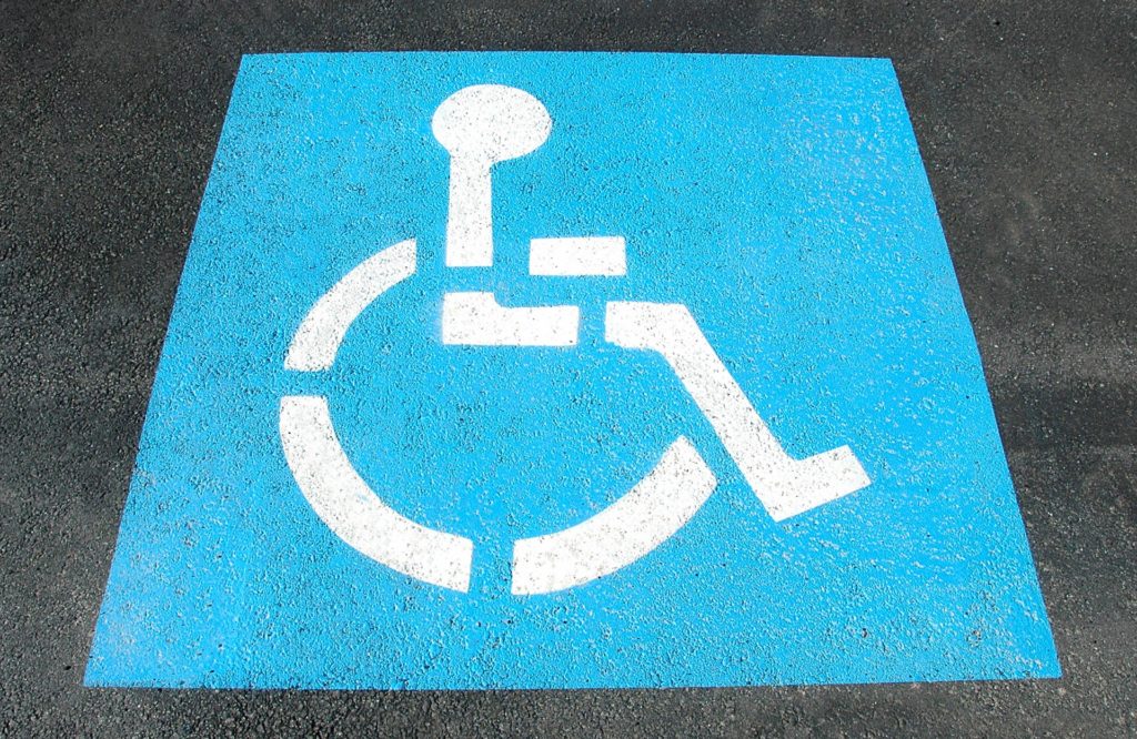 Disabled parking space sign painted on tarmac