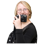 A smiling young woman holding a camera