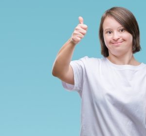 woman holding a mobile phone, she is giving a thumbs up.