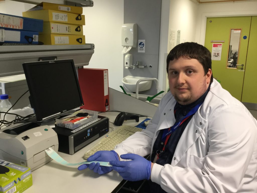 Young man in a white coat working in a laboratory