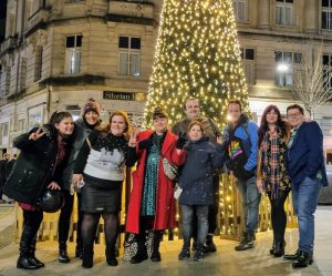 A group of Gig Buddies standing in front of a huge Christmas tree in Newport town centre