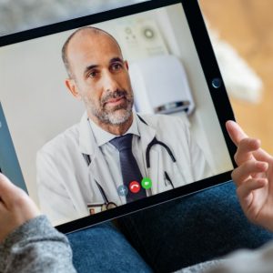 A person speaks to a doctor via a video call