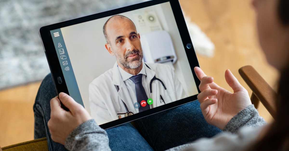 A person speaks to a doctor via a video call