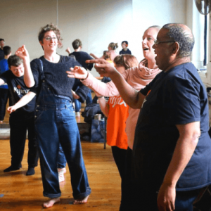 A group of people rehearsing a theatre performance