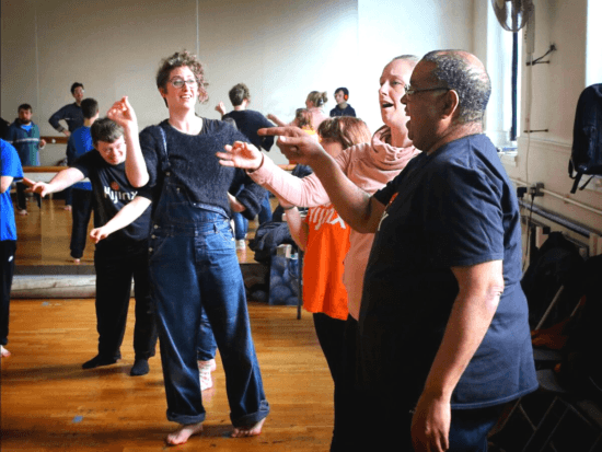 A group of people rehearsing a theatre performance