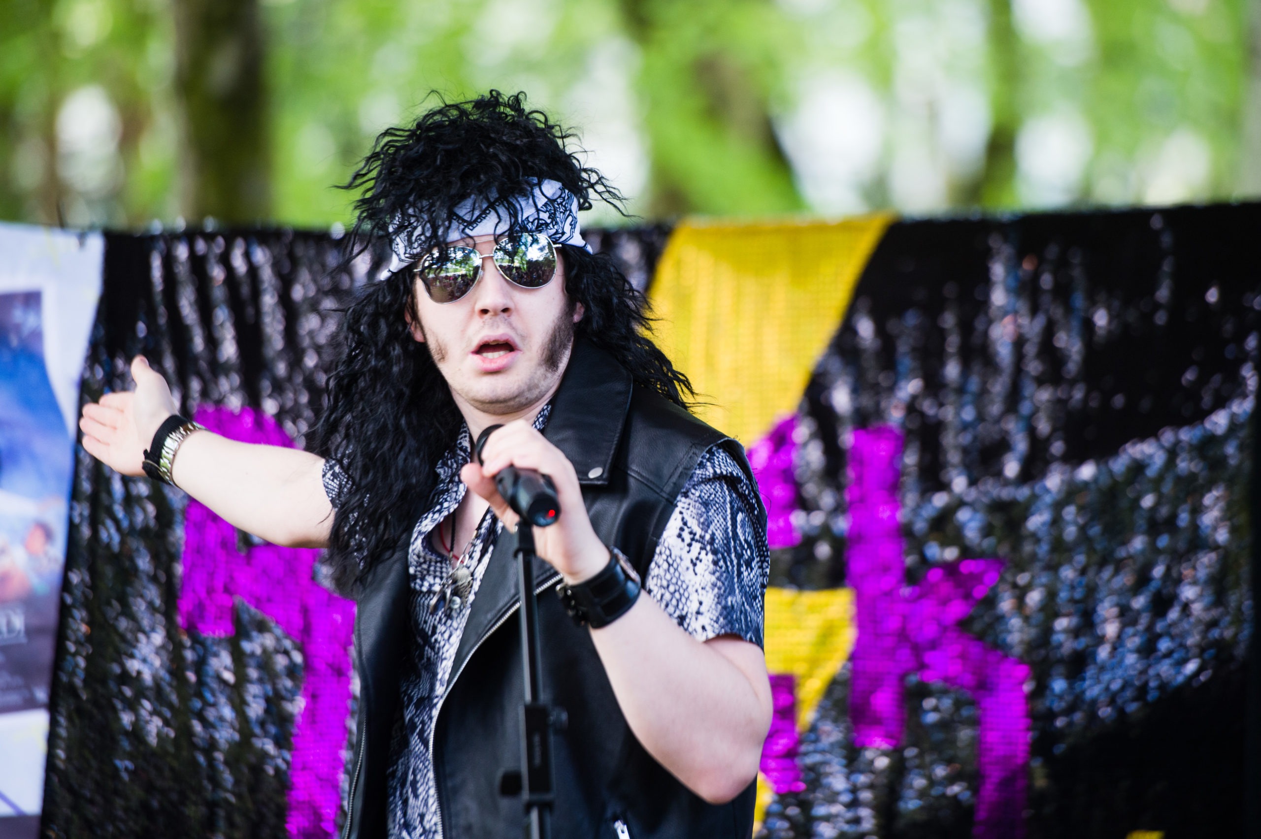 A man on stage sings into a microphone