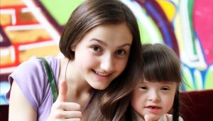 Mum and daughter smiling and giving a thumbs up