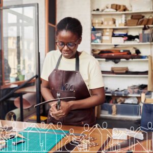 A black woman working in a leather makers workshop