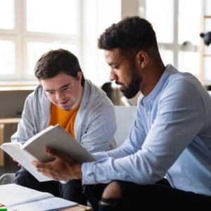 2 young men looking at a book together